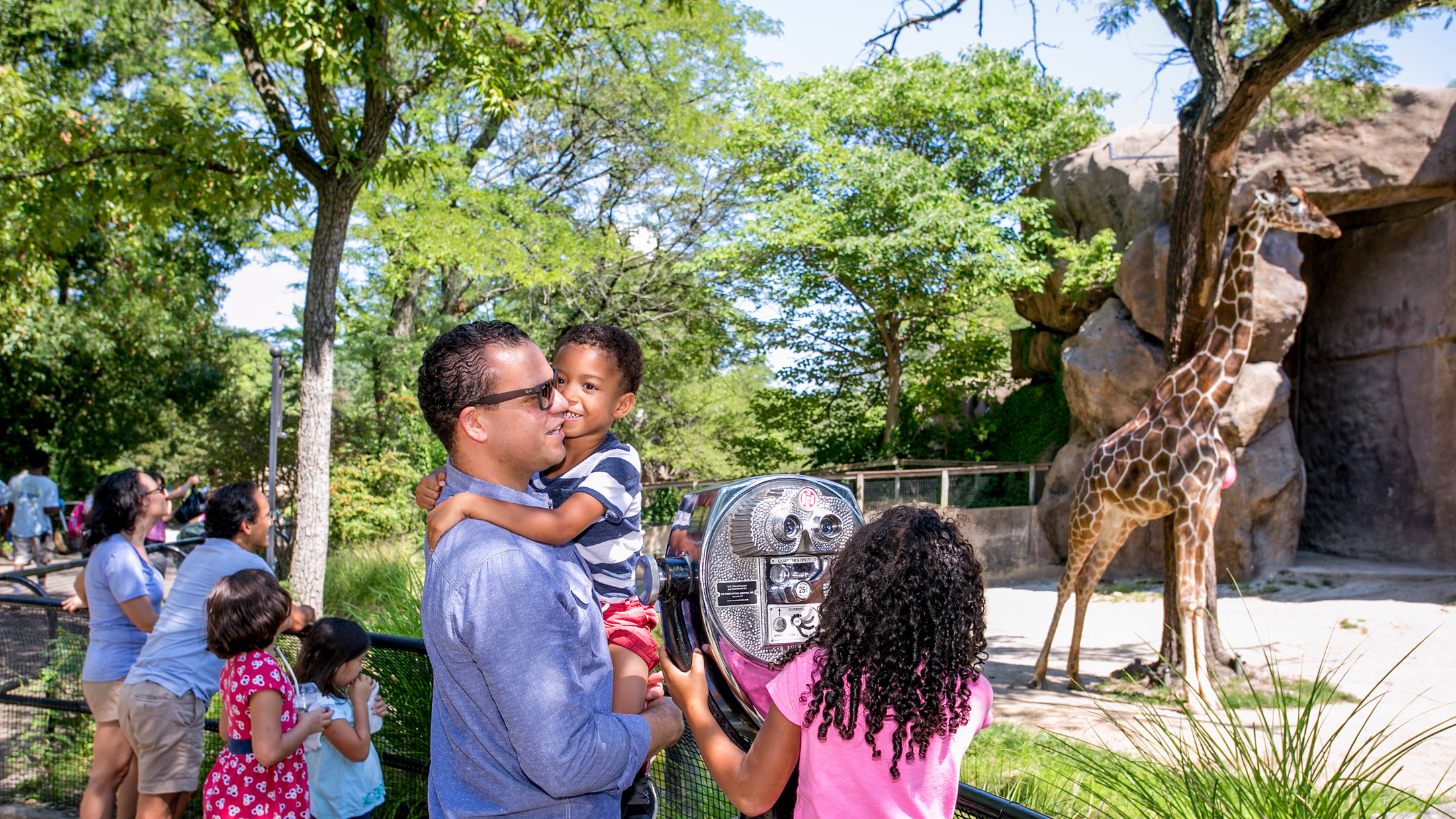 philly zoo father and kids looking at a giraffe